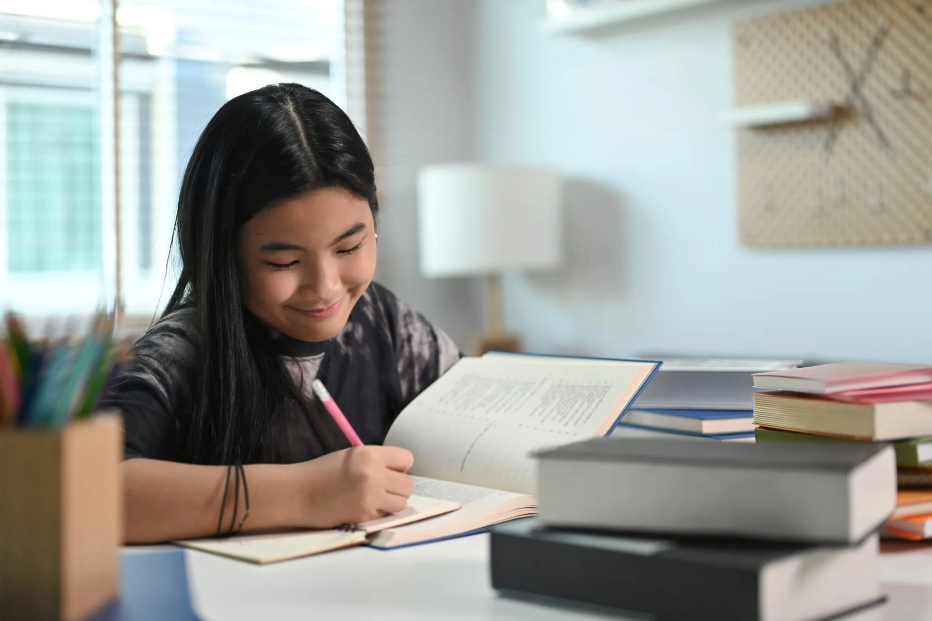 smiling teenage girl doing homework at home 2026 01 06 09 01 39 utc (1)